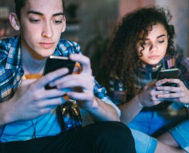 deux jeunes accros à leur téléphone