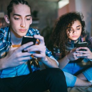 deux jeunes accros à leur téléphone